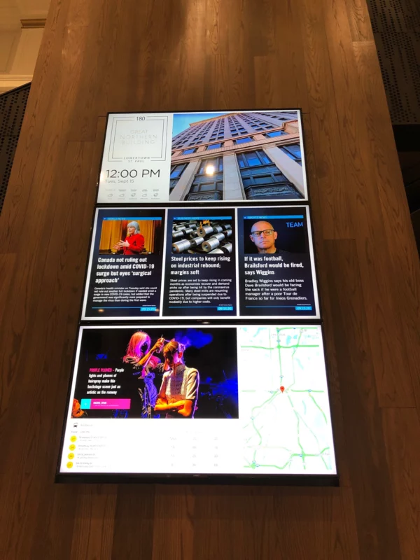 Multi-screen video wall with three displays featuring news highlights and infotainment.