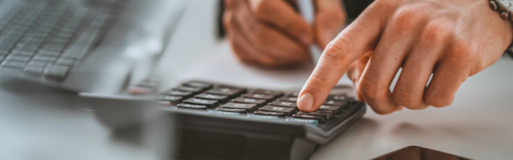 Hand doing a calculation of cost of medical office building directory