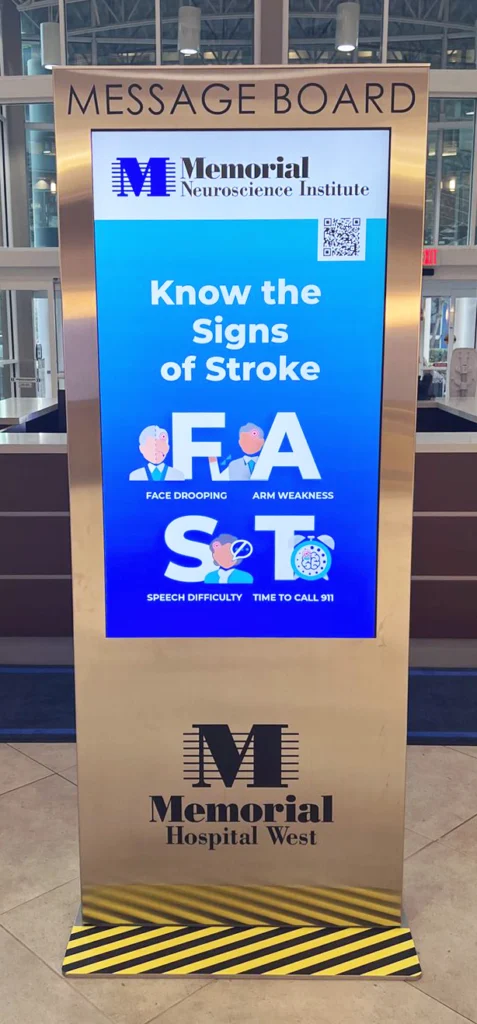 Memorial Hospital West tall digital interactive kiosk in a medical office building lobby with stroke signs program messaging.