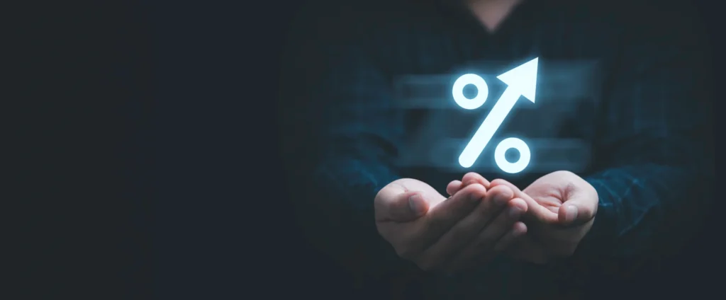 Person hands holding a glowing upward percent sign to signal increasing ROI of digital signage.