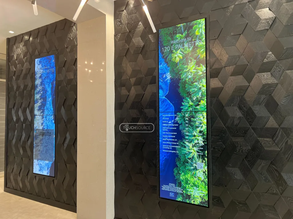 two side-by-side stacked vertical LED digital displays with green images demonstrating sustainable digital signage.