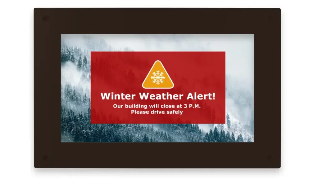 Winter Weather Alert on a framed monitor: building closes at 3 P.M.—Please drive safely.